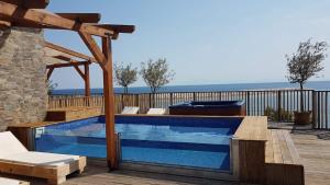 a swimming pool with a wooden deck and a swimming poolvisor at Hotel Menel The Tree House- Adults only in Limenaria