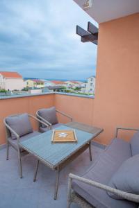 un patio con tavolo e sedie sul balcone. di Apartment Tara with pool a Povljana (Pogliana)