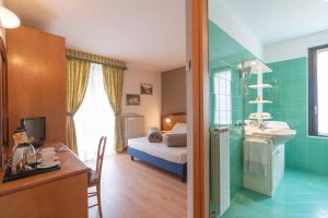 łazienka z umywalką oraz pokój z łóżkiem w obiekcie Hotel Posta w mieście Aprica