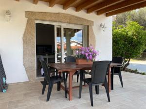 a wooden table and chairs on a patio at Giorgia&Greta- relax casa vacanze in Olbia