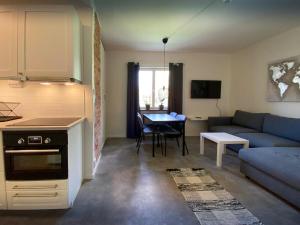 een keuken en een woonkamer met een bank en een tafel bij B&F Lägenheter in Nora