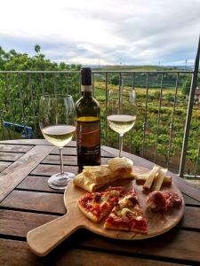 einen Tisch mit zwei Gläsern Wein und einem Teller Essen in der Unterkunft Cascina San Bernardo in Magliano Alfieri