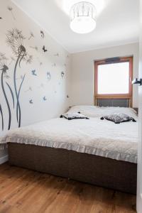 a bedroom with a bed with butterflies on the wall at GDAŃSK blisko MORZA nowy Apartament in Gdańsk