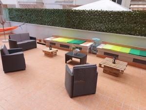 un patio con muebles y mesas en un edificio en @home Napoli, en Nápoles