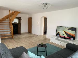 a living room with a couch and a flat screen tv at Casa Blanca 3 in Ottenheim