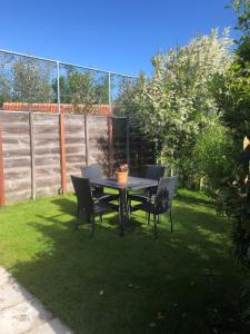 ザウテランデにあるVakantiewoning Scheldestraat 12の芝生の庭のテーブルと椅子