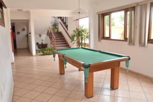 a pool table in a room with a staircase at Pousada Mirante da Enseada in Bertioga