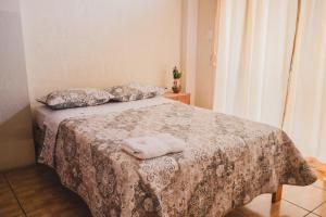 a bed with a blanket and two pillows on it at LOS BALCONES PUYO in Puyo