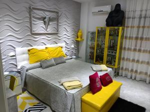 - une chambre dotée d'un lit avec des oreillers jaunes et rouges dans l'établissement Sirenamar, à Torre del Mar