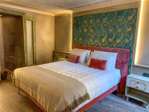 a bedroom with a large bed with a painting on the wall at DIMORA SCURONE in Cannobio