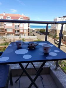 una mesa azul en un balcón con vistas al océano en Студио, en Lozenets