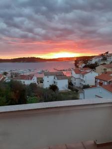 vistas a la puesta de sol desde el balcón de una casa en Apartmans and rooms Petra en Rab