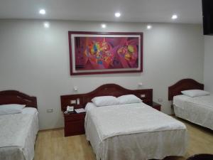 ein Schlafzimmer mit 2 Betten und einem Wandgemälde in der Unterkunft HOTEL CENTRAL in Chiclayo