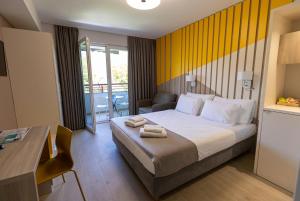 a hotel room with a bed and a table and a desk at Apartments Kanevce City Center in Ohrid
