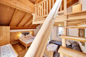 Cabaña de madera con altillo con cama y escaleras en Appartements Gasthof Schleifmühle Unterammergau, en Unterammergau