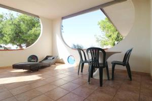 a room with two chairs and a table and two windows at Nirvana Club Village in Botricello