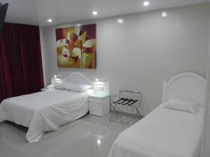 sypialnia z 2 łóżkami i obrazem na ścianie w obiekcie HOTEL CENTRAL w mieście Chiclayo
