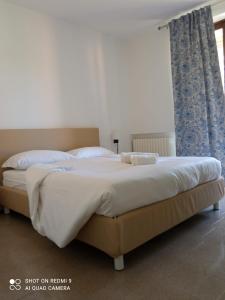 - une chambre avec un grand lit et des rideaux bleus dans l'établissement BETULLA BIANCA, à Bardolino