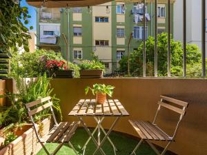 una mesa y 2 sillas en un balcón con plantas en Villa Vaghi Rooms, en Cagliari