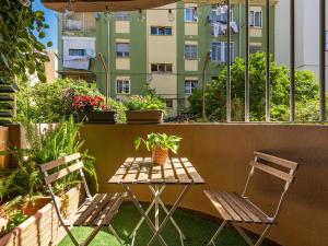 einen Tisch und zwei Stühle auf einem Balkon mit Pflanzen in der Unterkunft Villa Vaghi Rooms in Cagliari