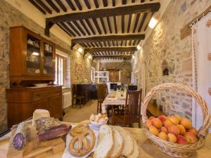una cocina con una mesa con pan y una cesta de fruta en Isola Delle Api, en Bagni di Petriolo