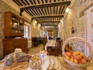 a kitchen with a table with bread and a basket of fruit at Isola Delle Api in Terme di Petriolo