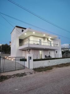 ein weißes Gebäude mit einem Balkon an der Seite in der Unterkunft Villa Angelina Ksamil in Ksamil