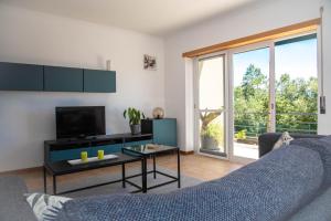 een woonkamer met een bank en een tv bij Casa Gemeos in Alcobaça