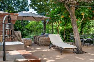 a chair sitting under an umbrella on a patio at Luksuzni apartmaji v centru Portoroža z vrtom in parkiriščem - Luxury Apartments in Portoroz Center with Garden & Parking in Portorož
