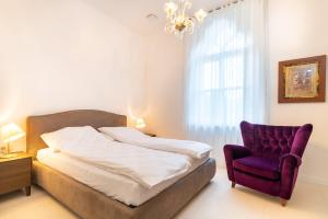 a bedroom with a bed and a purple chair at Luxury Apartments Portoroz in Portorož