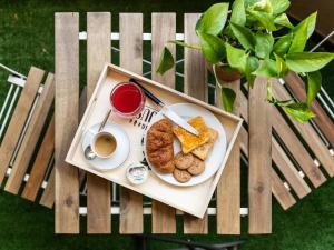 un plato de comida y una taza de café en una silla en Villa Vaghi Rooms, en Cagliari