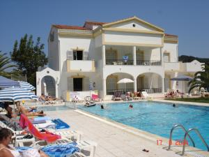 a large house with a swimming pool in front of it at Alessandro in Sidari