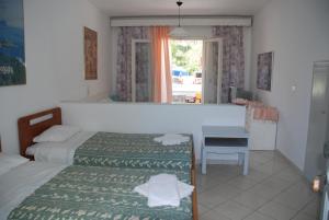 a bedroom with two beds and a desk and a mirror at Alessandro in Sidari