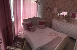 ミエンジズドロイェにあるHoryzont 214のピンクの壁のベッドルーム1室(白い大型ベッド1台付)