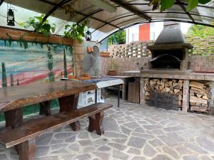 una cocina al aire libre con bancos de madera y horno en CLUA Holiday House, en Porto Ceresio