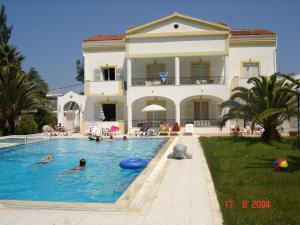 a house with a swimming pool in front of a house at Alessandro in Sidari