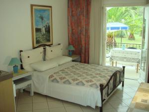 a bedroom with a bed and a table with an umbrella at Alessandro in Sidari