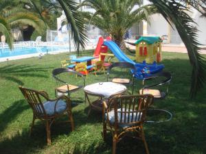 a group of chairs and a playground with a slide at Alessandro in Sidari