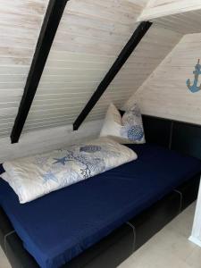 1 cama con 2 almohadas en una habitación en Ferienhaus Butterblume, en Südbrookmerland