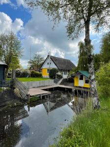 una casa con un ponte sopra un laghetto di Ferienhaus Butterblume a Südbrookmerland