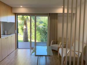 a kitchen and living room with a glass table at Quinta de Santa Ana, em Vizela in Infias