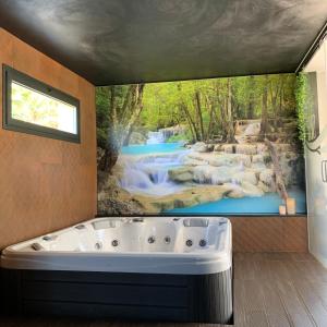 eine Badewanne in einem Zimmer mit einem Wasserfall-Wandbild in der Unterkunft Quinta de Santa Ana, em Vizela in Infias