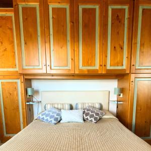een bed met houten kasten erboven en 2 kussens bij Paradiso Imperfetto Rooms in San Zeno di Montagna