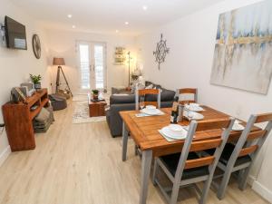 a living room with a table and a couch at Captain's Quarters - Apartment 2 in Benllech