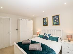 a bedroom with a large white bed and two lamps at Captain's Quarters - Apartment 2 in Benllech