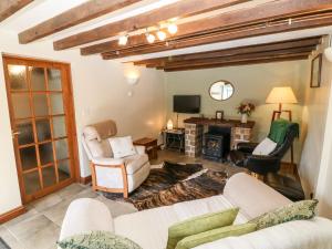 a living room with couches and chairs and a fireplace at Stable 1 in Llanbedrog