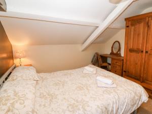a bedroom with a bed and a dresser at Stable 1 in Llanbedrog