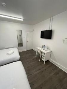 een kamer met een bed, een bureau en een televisie bij County serviced accommodation in Liverpool