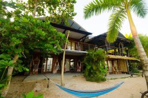 a hammock in front of a house on the beach at Skully's House in Bocas del Toro