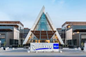 利雅德Radisson Blu Hotel Riyadh Qurtuba的一栋前面有招牌的建筑物